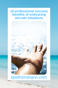 A hand reaching out towards the sea. Text: 10 professional success benefits of embracing win-win situations. tipsfromsharvi.com, courtesy of Canva.
