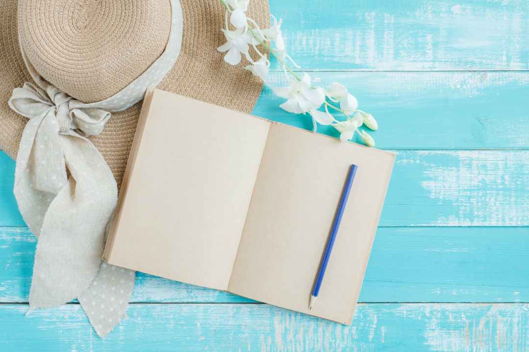 white notebook and blue pencil