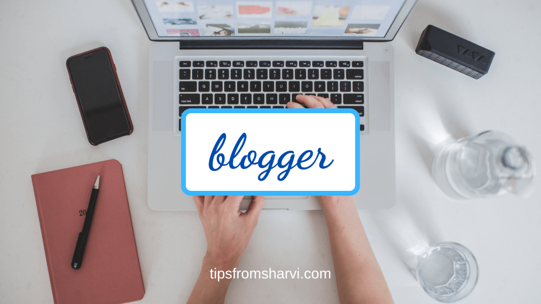 Working on a laptop with a phone, paper agenda, pen, glass of water, and a few objects on a desk. Text: blogger, tipsfromsharvi.com.