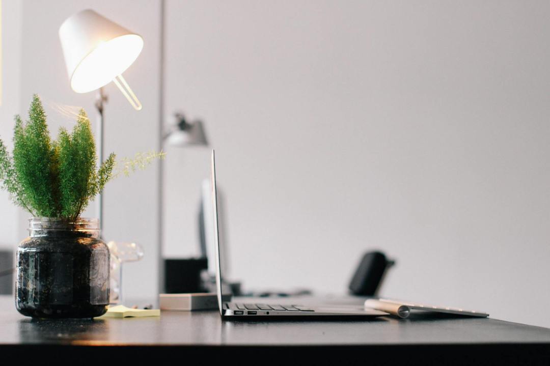 grey laptop on black wooden desk