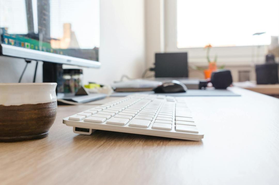 selective focus photography of wireless keyboard on desk